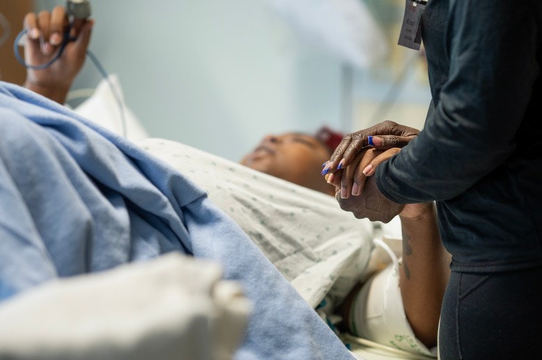 Latrina Jackson, the mother of Detranay Blankenship, holds her hand as she is about to give birth for the first time at Martin Luther King Community Hospital in Los Angeles, on March 22, 2024. Photo by Jules Hotz for CalMatters