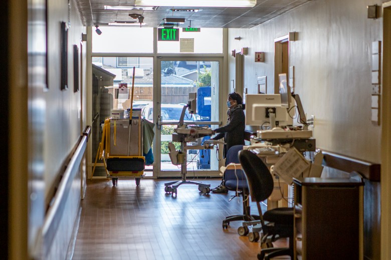 A medical personnel working on her computer in the corridor of Hazel Hawkins Memorial Hospital in Hollister on March 30, 2023. Photo by Larry Valenzuela, CalMatters/CatchLight Local