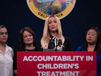 Flanked by legislators, Paris Hilton speaks in support of Senate Bill 1043 during a press conference at the Capitol Annex Swing Space on April 15, 2024. SB 1043 would require more transparency for children's treatment facilities that are licensed in California. Hilton spoke of her traumatic experience during her teenage years at similar facilities. Photo by Miguel Gutierrez Jr., CalMatters