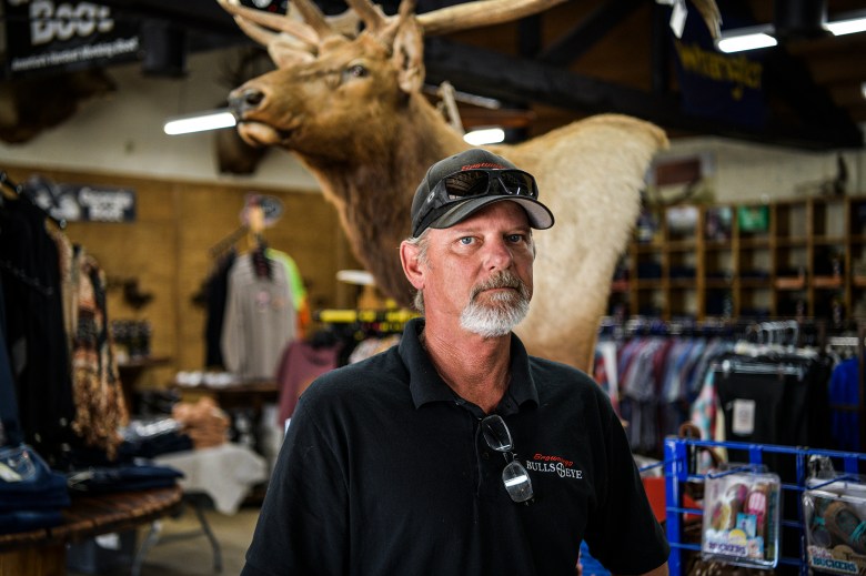 Jamie Browning, who worked at the Chuckawalla Valley State Prison as a correctional councilor for 18 years, stands for a portrait inside his family-operated business, Browning’s Bullseye, in Blythe on May 8, 2023. “The people who buy here are six-figure employees from the prison—they want to spend on these things,” Browning said. “It’s going to hurt Blythe when they shutdown Chuckawalla, of course.” Photo by Pablo Unzueta for CalMatters