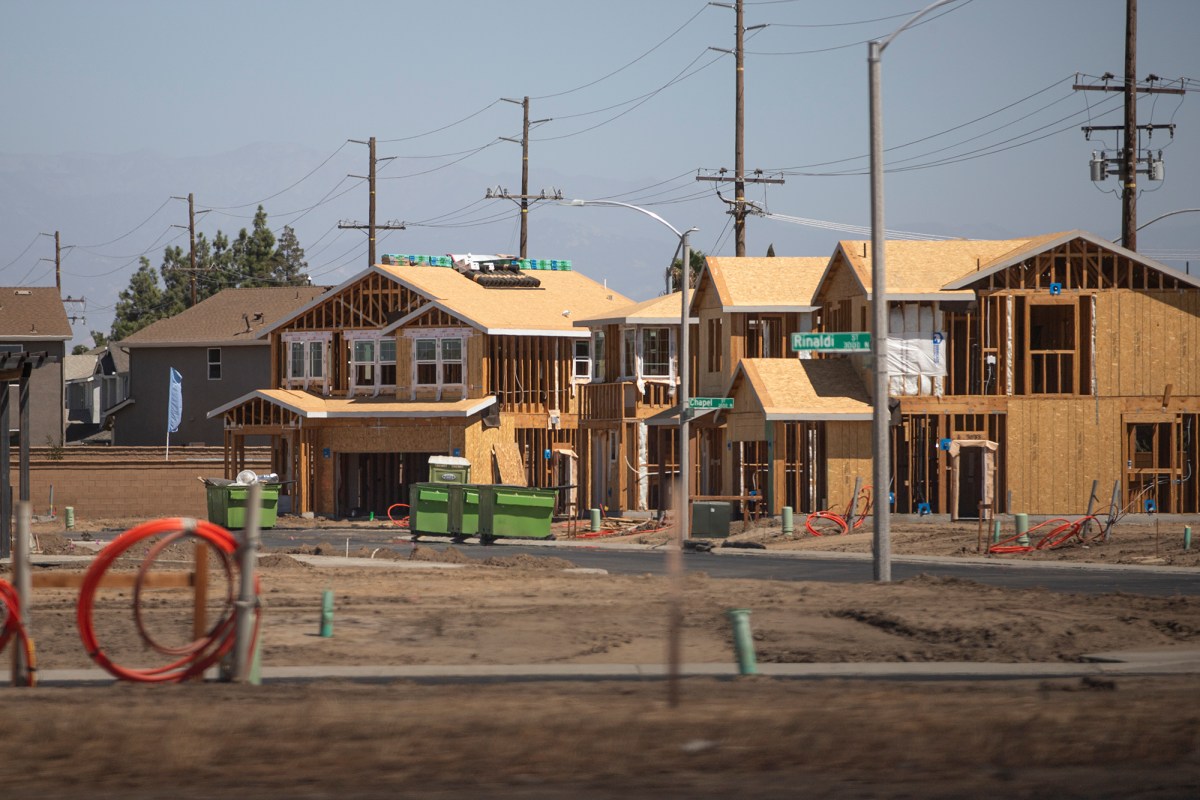 The wooden frames of houses under construction are visible on a residential street in Goshen.