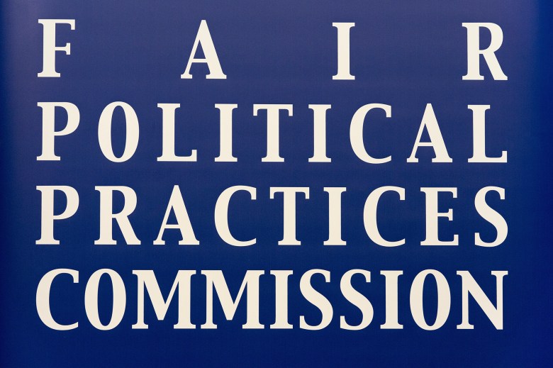 A blue sign with bold white lettering reads "Fair Political Practices Commission".