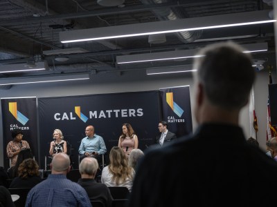 People on a panel speak as attendees listen at the CalMatters studio in Sacramento.