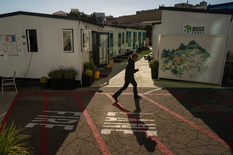 Resident Johnny Nielson walks through the DignityMoves tiny home village in downtown San Francisco, on Oct. 3, 2023. The program provides interim supportive housing to individuals experiencing homelessness. Photo by Loren Elliott for CalMatters