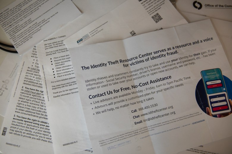 A close-up view of a flyer for identity theft resources and information that sits on top on other various documentation on a desk.