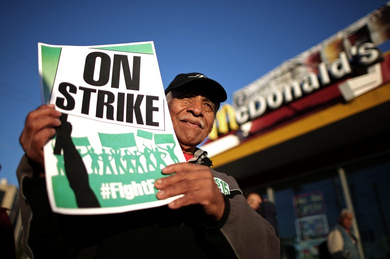 Fast food worker Rogelio Hernandez, 72, who works at Carl's Jr., has a wife and four kids and earns roughly $290 every two weeks, participates in a "Fight for $15" wage protest in Los Angeles on Nov. 29, 2016. REUTERS/Lucy Nicholson