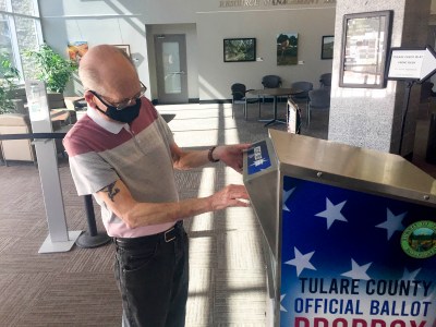 Jack Van Rooy places his mail-in ballot envelope into an official drop box in Visalia on Oct. 19, 2020. Photo by Lewis Griswold for CalMatters.